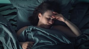 A beautiful brunette woman lies alone in bed and regrets something. Suddenly she remembers an important thing for herself. Night thoughts and memories. The woman can't sleep. Night insomnia.