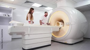 A rengolok doctor and an assistant are preparing equipment for a computed tomography scan in a modern medical center. Concept of treatment, healthy body and computer images. Stock Video