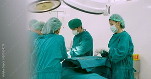 Team of surgeons in operating theater performing operation on a patient.