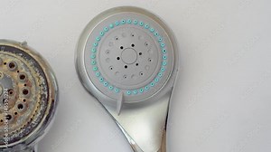 close-up of old dirty shower head and new clean shower head