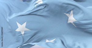 Flag of the Federated States of Micronesia waving at wind with blue sky in slow, loop Stock Video