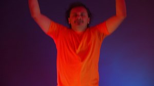 Crazy man dancing in the neon light of the ridiculous dance. funny man on a colored blue background Premium Stock Video Footage