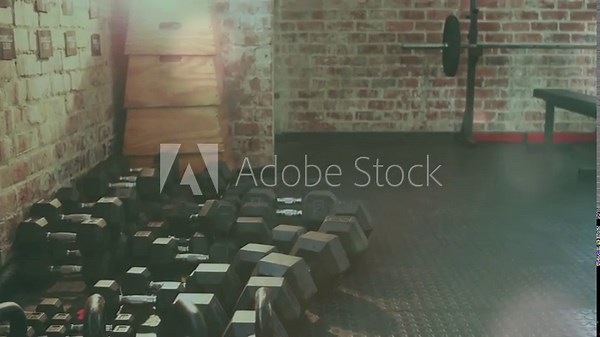 Camera starting pullback and panning right, kettlebells staying front while revealing gym layout