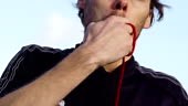 Slow Motion clip of a sports referee blowing a whistle whilst...