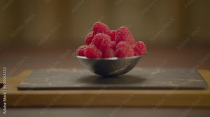 Slate board with bowl of raspberries, full of antioxidants and bursting with flavor