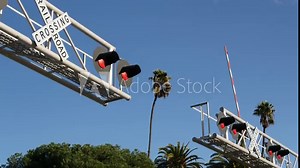 Level crossing warning signal in USA. Crossbuck notice and red traffic light on rail road intersection in California. Railway transportation safety symbol. Caution sign about hazard and train track.