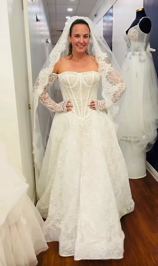 Talk about a showstopper. This jaw-dropping drop waist gown is pure couture magic — featuring delicate lace from neckline to hem, a dramatic structured bodice, and those unforgettable coordinating gloves that tie the entire bridal look together. 🤍 Every inch of this gown feels regal — the detachable sleeves, low basque waist, and intricate button detailing down the back create the kind of elegance that never goes unnoticed. If your dream look is all about timeless glamour with a modern twist, t