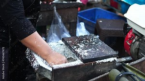 grating coconut using a machine is done by Indonesian women