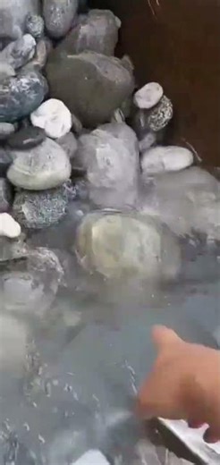 the process of dredging rocks in a river using heavy equipment or an excavator