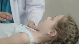 Close-up of pediatric examination, doctor checking young girl’s nose...