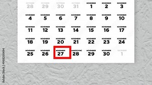 Close-up of a wall calendar with a red cursor moving to Thanksgiving Day date 2024