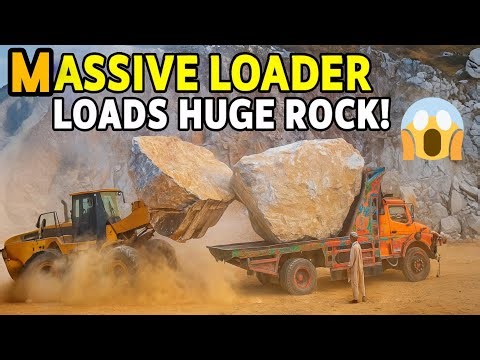 Massive Rock Loaded Into Huge Dump Truck by Heavy Loader