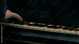 The man plays grand piano - all on fire.