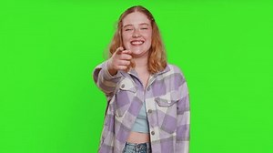 Amused lovely woman pointing finger to camera, laughing out loud, taunting making fun of ridiculous appearance, funny joke anecdote. Pretty redhead girl isolated alone on green chroma key background