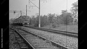 Train moving by railway tracks, black white film, close up. Train wagon move with speed. Travel by rail through countryside on summer nature background. Vintage old archive. Retro 1980s transportation