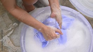 Woman washing clothes by hands. Washing by hand is therefore a great way to keep them looking new and fresh for longer.