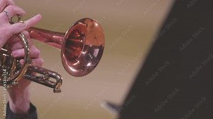 A slow motion video of a trumpet player playing their cornet during a live performance