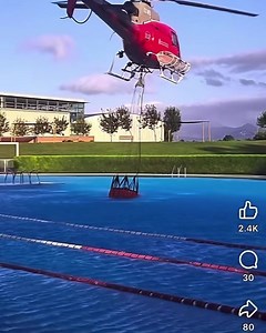 Helicopter dipping from an outdoor pool to fight a wildfire. “Lane swim is cancelled” Watch other wildfire videos at WildfireHQ on YouTube. | Wildfire HQ
