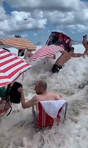 Moment freak 11ft high wave hits tourist beach washing away sunbathers