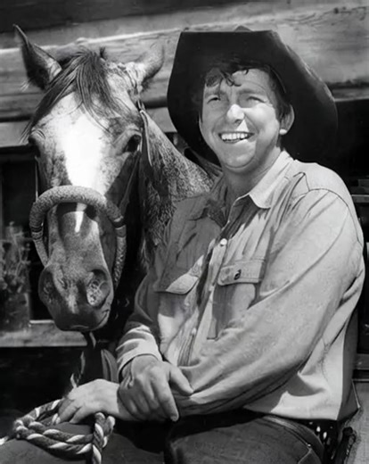 Actor Slim Pickens seated next to a horse. | Rodeo Cowboy Hall of Fame
