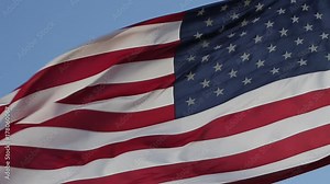 USA flag flaping in wind. Elegant Nylon American Flag Waving in the Wind. Close-up of an American flag flying in the wind against a background of clear sky. Close up of American flag waving.