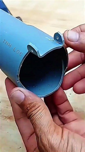 Blue pipe rests in hand, cut-out precise, letters etched clear across smooth surface.