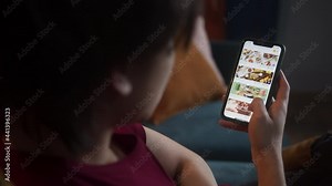 Asian man choosing a meal in online shop application, Black Friday week, shopping by phone, e-commerce payment, big marketplace. Young Korean student using food delivery. Stock Video