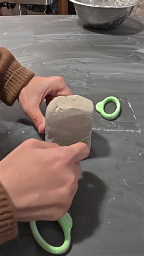 Cutting a block of clay into smaller sections before rolling it out into a slab. I smooth and compress the surface with a rib to help strengthen the clay and even out the thickness. This step is simple, but it makes a big difference in how the piece behaves later on. #ceramicsprocess #porcelain #studiopractice #handmadeceramics #claywork