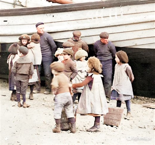 Filey fishermen positioning a herring coble, while the local waifs watch on and mingle. | Stephen Eblet