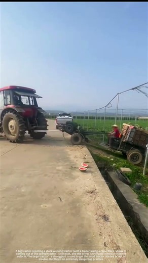 A large tractor is pulling a stuck walking tractor