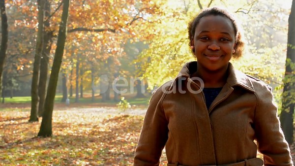 Une belle jeune fille africaine se tient dans les bois et donne ses cheveux lâches en queue de cheval