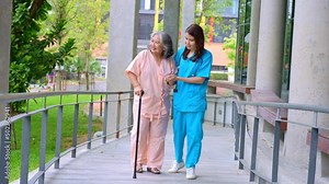 Doctor help old elderly Asian woman uses a walker and walking for physical therapy in the hospital. Concept of happy retirement With care from a caregiver and Savings and senior health insurance