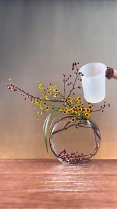 The grass, flowers and fruit branches in the mountains and fields seem to grow randomly, but they hide the most touching harmony. Pick a handful of wild chrysanthemums, break off a few branches of red fruits, and let them stretch in the glass container. The high and low staggered arrangement seems to recreate the posture of the wind blowing through the mountains and forests. The unpretentious wildness is the most natural - the vigor of the dead branches, the tenderness of the grass and flowers, 
