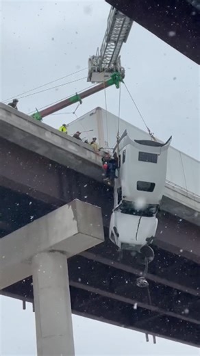Driver rescued from tractor-trailer dangling over bridge