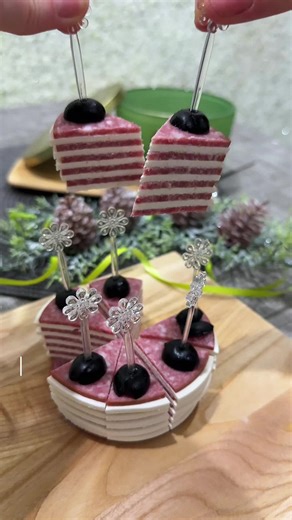 Новогодний рецепт за 5 минут: колбасные канапе с сыром и маслинами! 🌲🎄 Идеальная закуска на Новый год — красивая, вкусная и готовится моментально! Что нужно: ✅ Колбаса (нарезанная кружочками) ✅ Творожный сыр ✅ Маслины без косточек ✅ Шпажки Просто выкладываем колбасу и сыр слоями, сверху — половинка маслины, скрепляем шпажкой и разрезаем на сегменты. Готово! 🎬 Смотрите, как легко создать праздничную закуску, которая удивит гостей и украсит стол. 🔥 Сохраняйте, чтобы не потерять, и ставьте лайк