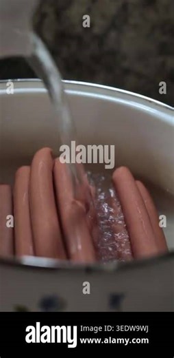 Close up of raw sausages hot dogs in pot with water pouring from tap, cooking preparation process in kitchen, food concept Stock Video Footage - Alamy