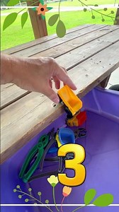 5 Toy Dump Trucks Driving Into Purple Bin