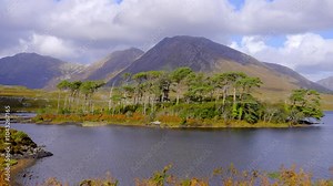 Derryclare Lough at Connemara National Park in Ireland - A stunningly beautiful mountain landscape featuring a tranquil lake surrounded by lush greenery and trees