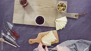 Flat lay. Arranging gourmet cheese, crakers, and fruits on a board for a large cheese board.