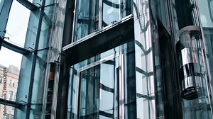 Modern glass office building exterior with elevator shaft design detail