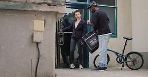 Food Delivery Courier Hands Food to Woman