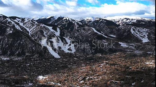 Downtown Aspen ski town Winter morning blue sky clouds Aspen Mountain AJAX aerial drone Colorado Aspen Highlands Ski resort ski trails fresh snow Rocky Mountains neighborhood homes backwards motion