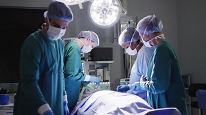 Premium stock video - Video of diverse group of surgeons operating on patient in operating theatre