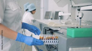 Laboratory worker puts racks with blood samples into a modern automated medical equipment. Stock Video