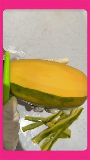 Quickly peeling the skin of a ripe mango, revealing its juicy, golden flesh in seconds.