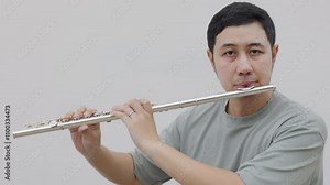 A professional asian flute player skillfully performs with a silver flute, showing classical artistry of wind instruments, the polished flute. This shows talent, dedication, and musical passion.