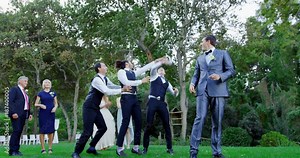 Garter toss by happy groom and groomsmen catch it