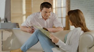 Young man, woman checking map, talking, planning family vacation Stock Video