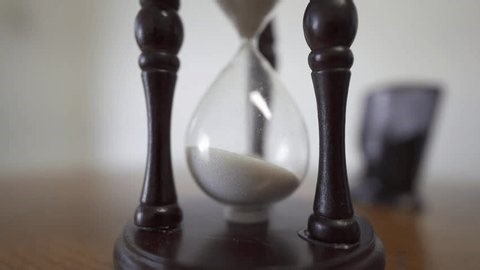 clip-3997630685-closeup-sand-watch-running-out-time-above