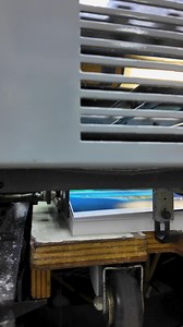 A printing machine operates at high speed, featuring grippers releasing paper while behind a safety cage. The process is efficient and highlights the intricate mechanics involved in paper handling. | Premium Stock Video Footage